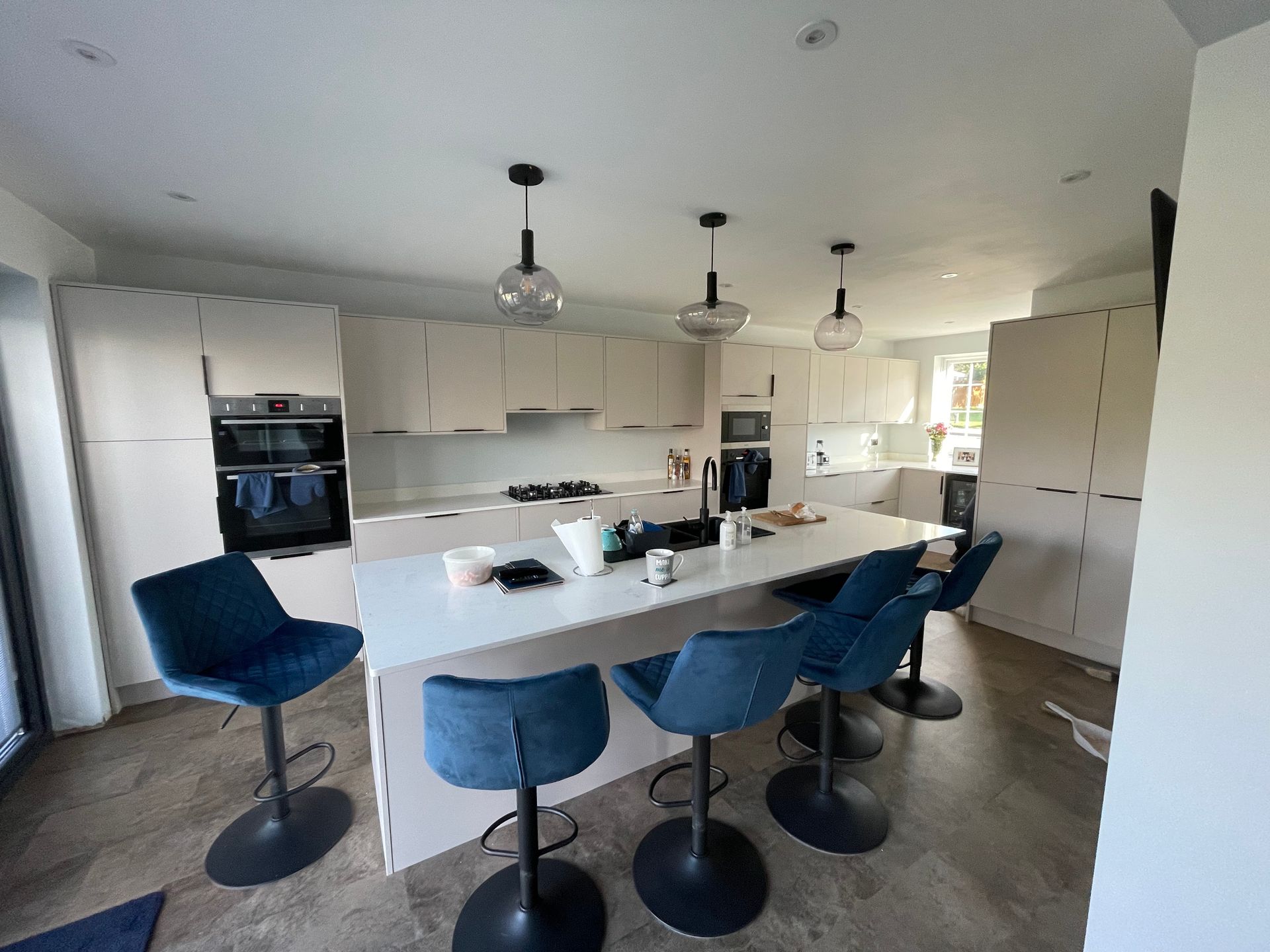 New kitchen fitted into the extended open-plan space, with handleless units, quartz worktops, and under-unit lighting.