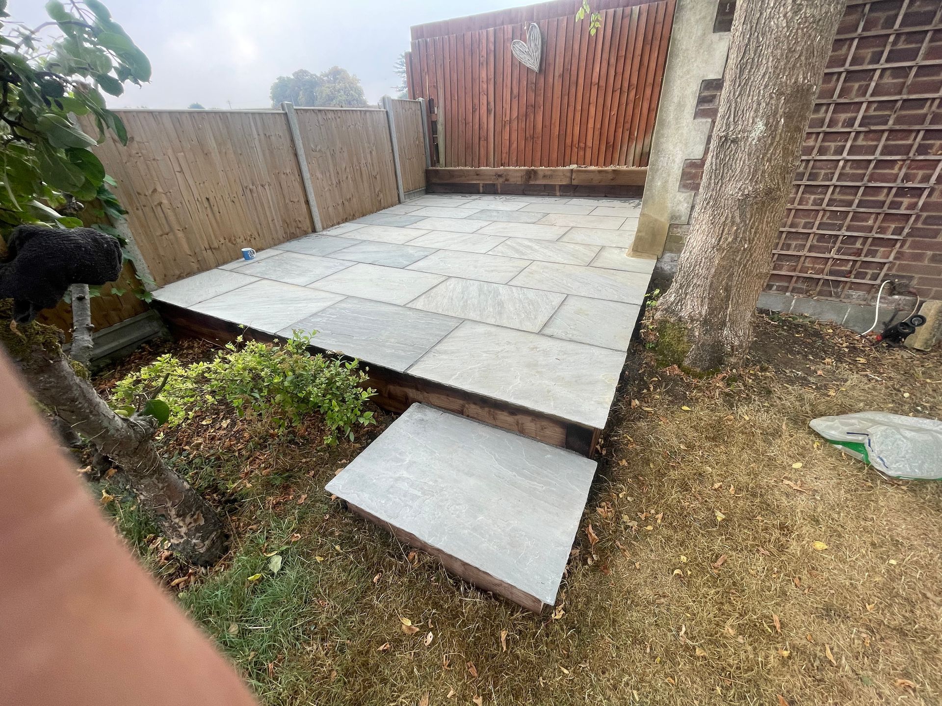 New porcelain patio installation with drainage and clean border finish.