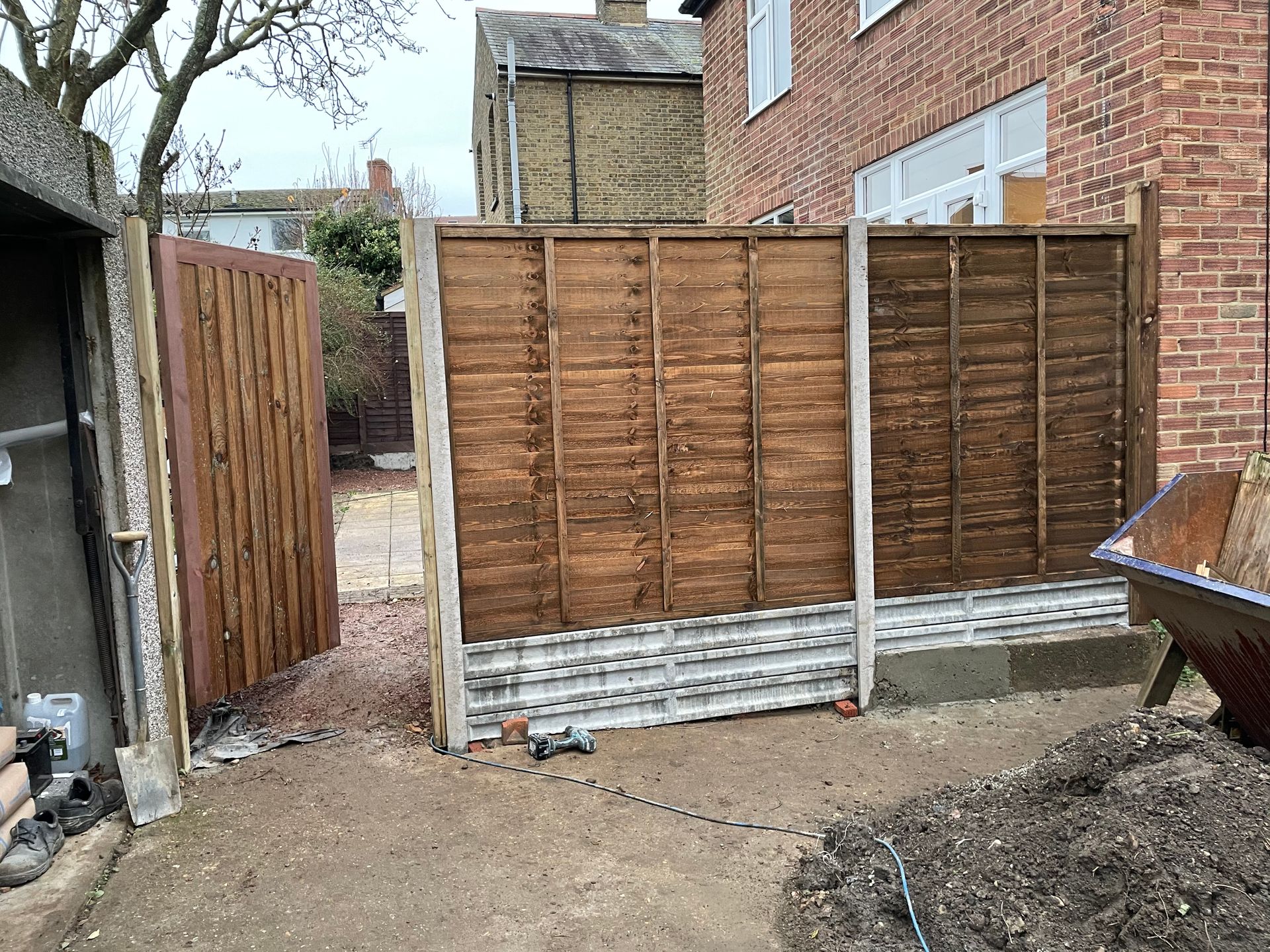 Complete front-to-back garden redesign with paving, raised beds, turfing, fencing, and structured planting.