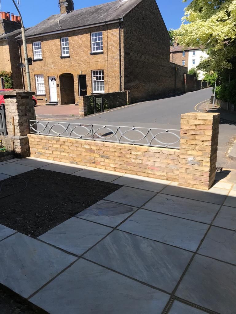 Comprehensive garden redesign with defined paving zones, turfed lawn, and structured planting throughout.