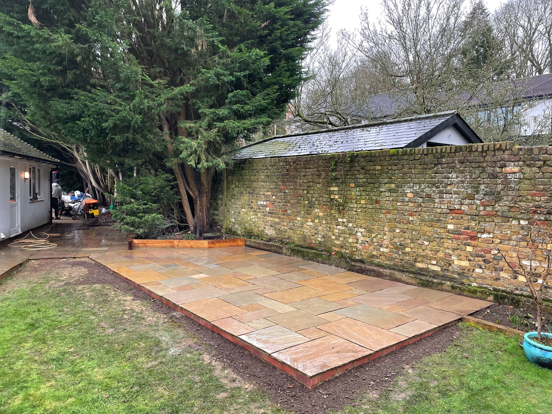 Rear garden patio extension with raised beds, returfed lawn, and replanted borders.